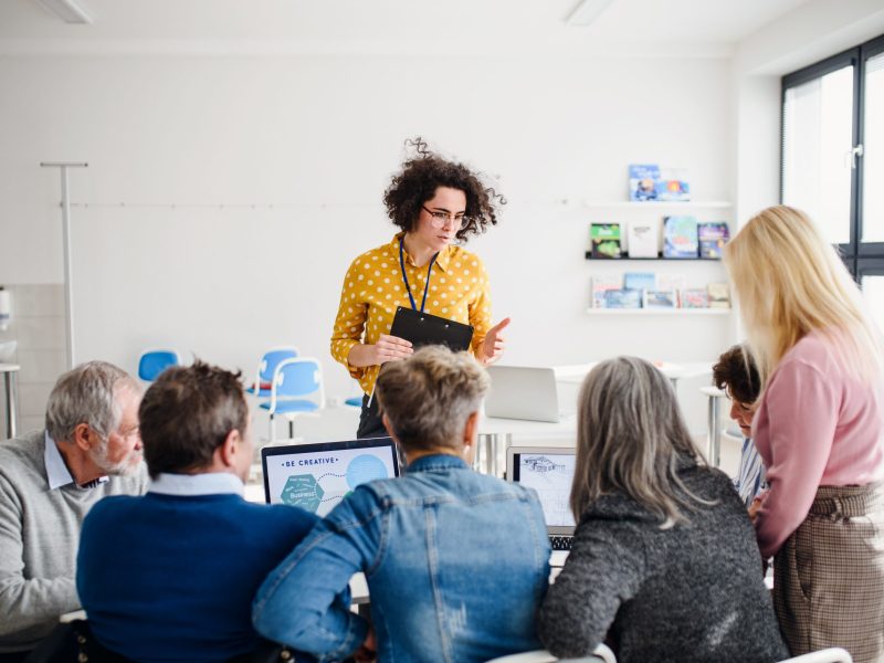 Group of concentrated senior people attending computer and technology education class.