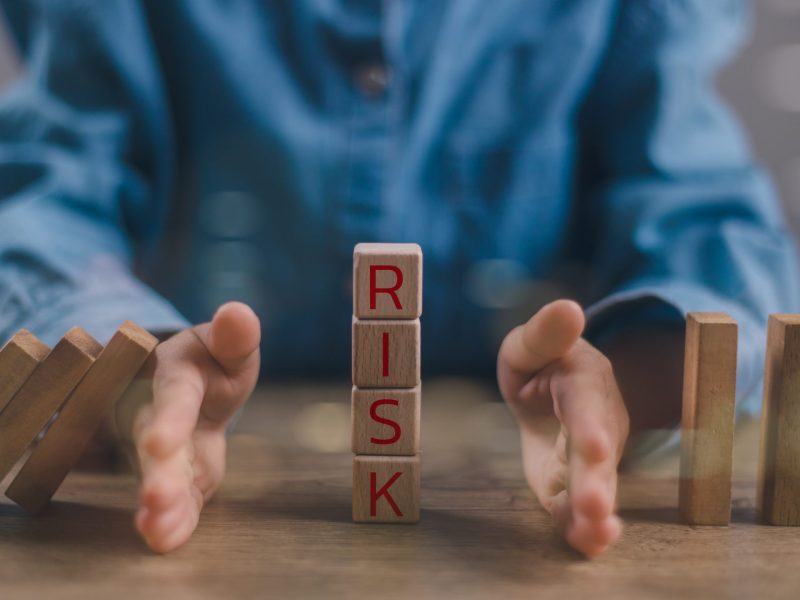 Hand of a businessman who is stopping or preventing a falling block.Risk protection concept, Eliminating the risk